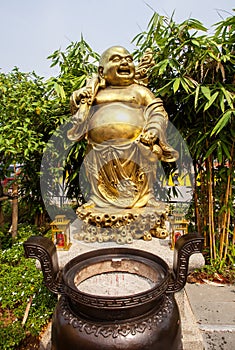 Statue of the Golden smiling Buddha or Hotei is the chinese god of happiness, wealth and good luck. photo