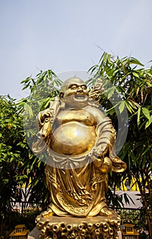 Statue of the Golden smiling Buddha or Hotei is the chinese god of happiness, wealth and good luck. photo