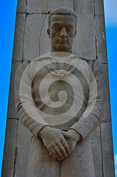 Statue in gray stone of a grieving sailor