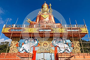 Statue of Guru Rinpoche, the patron saint of Sikkim that view at the base from front and below with construction site.