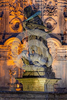 Statue of Hercules standing on a fountain in Olomouc. In the background, the column of the Holy Trinity, written in UNESCO