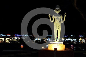 The statue of a Hindu deity with four hands and several faces, night lighting, Asian culture