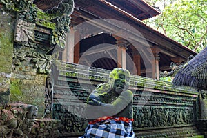 The statue in the Hindu Temple in Ubud Monkey Forest covered by moss, Bali Island, Indonesia