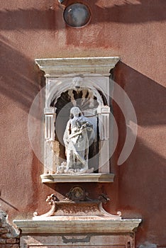 Statue on a house facade in Venice