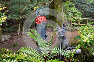 Statue of Jizo, enlightened monk who is the protector of the dead children in Japan. Jizo and water-spouting dragon photo