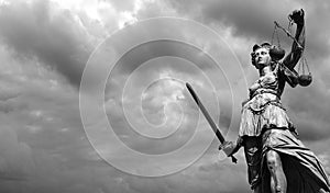 Statue of justice goddess Justitia with cloudy sky, Black and