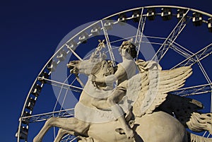 Statue of King of Fame riding Pegasus on the Place de la Concorde with ferris wheel at background, Paris, France
