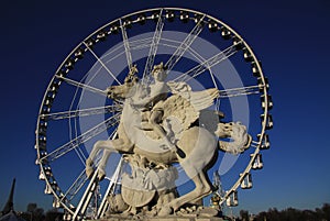 Statue of King of Fame riding Pegasus on the Place de la Concorde with ferris wheel at background, Paris, France