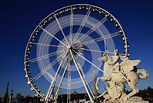 Statue of King of Fame riding Pegasus on the Place de la Concorde with ferris wheel at background, Paris, France