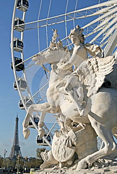 Statue of King of Fame riding Pegasus on the Place de la Concorde with ferris wheel and Eiffel tower at background, Paris, France