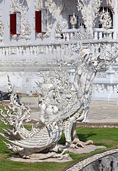 Statue of kinnara - exterior detail in famous Wat Rong Khun, or White Temple in Chiang Rai, Thailand