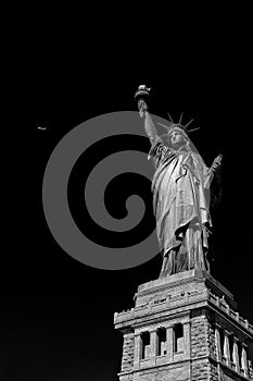 Statue of Liberty with black background and airplaine