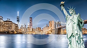 The Statue of Liberty with Brooklyn Bridge and Lower Manhattan background in the evening, Landmarks of New York City