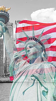 Statue of Liberty with a large american flag and New York skyline in the background