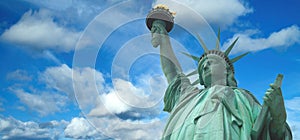 Statue of Liberty panorama with bright blue cloudy sky, New York