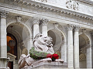 Statue of the lion in the new york library decorated for christmas