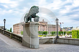 Statue of lion at Royal palace with Parliament house (Riksdag) at background, Stockholm, Sweden