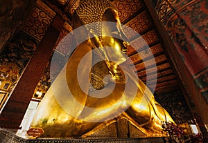 Statue of lying Reclining Buddha in Wat pho Pho Temple Bangkok Thailand, represents the entry of Buddha into Nirvana and the end