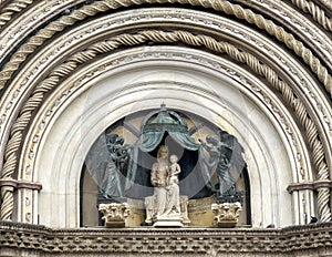 Statue of the Madonna and Child in the lunette of the facade of the monumental Orvieto Cathedral in Orvieto, Italy.