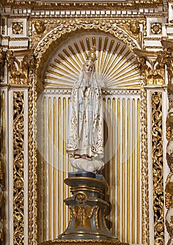 Statue of the Madonna with prayerful hands and a crown inside the Sanctuary of Our Lady of Nazare in Portugal.