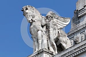 Statue of a man holding a winged horse on the Milan's main railway station