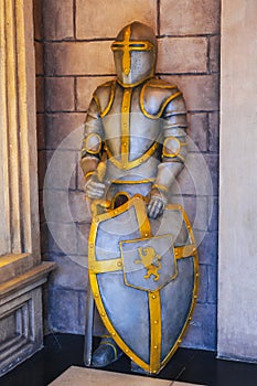 statue of medieval European knight in armor with sword and shield in castle