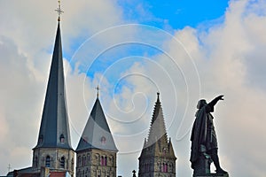 Statue of medieval man and chuch towers photo