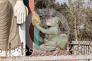 The statue of a monkey beside the statue of Buddha at Shreenagar