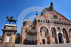 Statue of a mounted knight and the facade of the medieval church of St. Anthony in the city of Padua