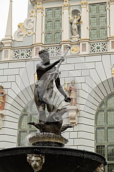 Statue of Neptune fountain in old town of Gdansk, Poland. Fountain of the Neptune and city hall. Old town travel