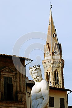 The statue of Neptune in Piazza della Signoria and the tower of Badia Fiorentina - Monastero in background in Florence.