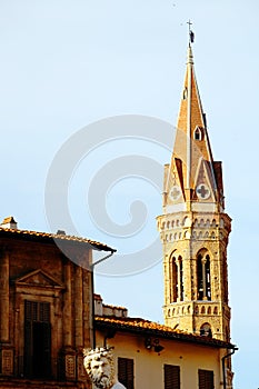 The statue of Neptune in Piazza della Signoria and the tower of Badia Fiorentina - Monastero in background in Florence.