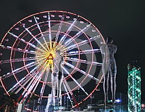 Statue of Nino and Ali at night on the carousel background and alphabetic tower. Batumi,Georgia at august of 2018