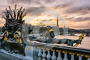The statue of a nymph ornamenting the Pont Alexandre III in Paris, with the Eiffel tower in the background at sunset