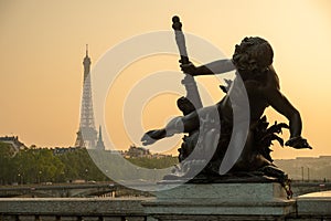 Statue of Nymphs with locks on Alexandre III bridge with Eiffel Tower in the background at sunset time in Paris