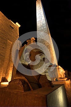 Statue and obelisk at Luxor temple at night