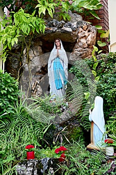 Statue of Our lady of grace virgin Mary view with natural background in the rock cave at Thailand. selective focus.