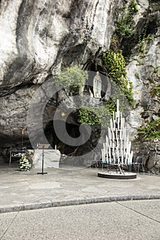 Statue of Our Lady of Immaculate Conception with a rosary in the Grotto of Massabielle in Lourdes