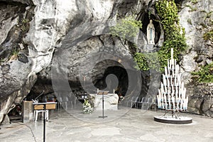 Statue of Our Lady of Immaculate Conception with a rosary in the Grotto of Massabielle in Lourdes