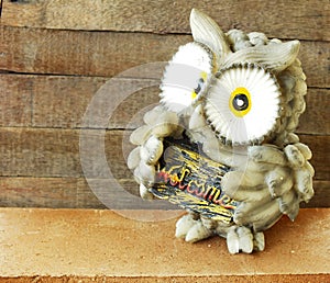 Statue of owl on wooden background still life