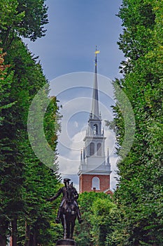 Statue of Paul Revere and spire of Old North Church between tree