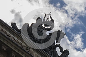 statue playing harp backlit with cloud sky, denmark, copenague photo