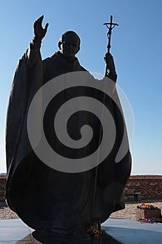 Statue of pope John Paul II with raised right hand and his cross in left hand, as installed on castle Nitra, Slovakia.