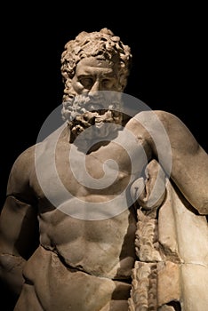 A statue of powerful Hercules, closeup, isolated in black