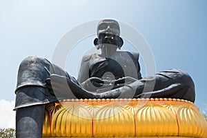 Statue of praying monk Luang Phor Thuad at Wat Bo Phuttharam, koh Samui, Thailand at picturesque green park