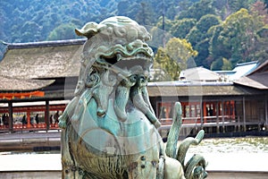 A statue protects the entrance to a temple in Japan