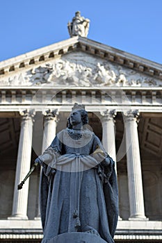 Statue of a queen with the fronton of a cathedral in the background in London