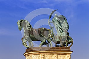 Statue representing Peace, a woman holding a palm frond on a chariot, on a colonnade in Heroes Square or Hosok Tere photo