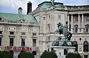 Statue with a rider on a prancing horse, located in front of the facade, of a historic building, in the museum district in Vienna.