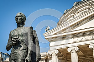 The statue of romanian national poet, Mihai Eminescu, placed in front of the iconic Ateneul Roman Romanian Athenaeum, a symbol photo